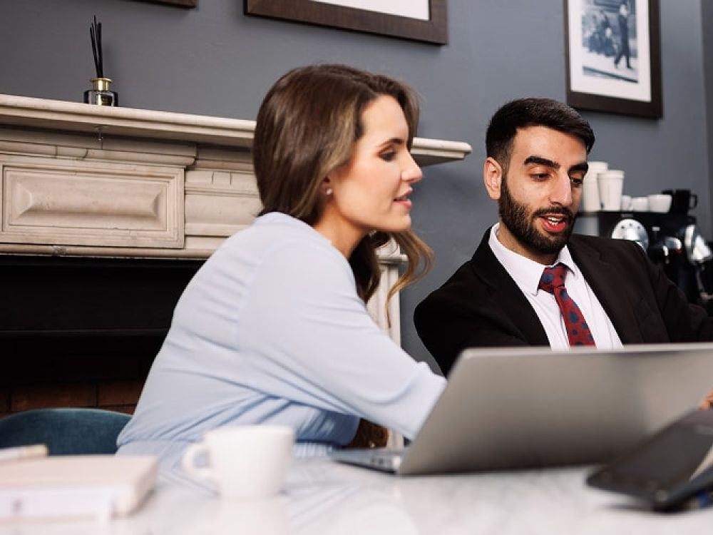 Two business people on laptops